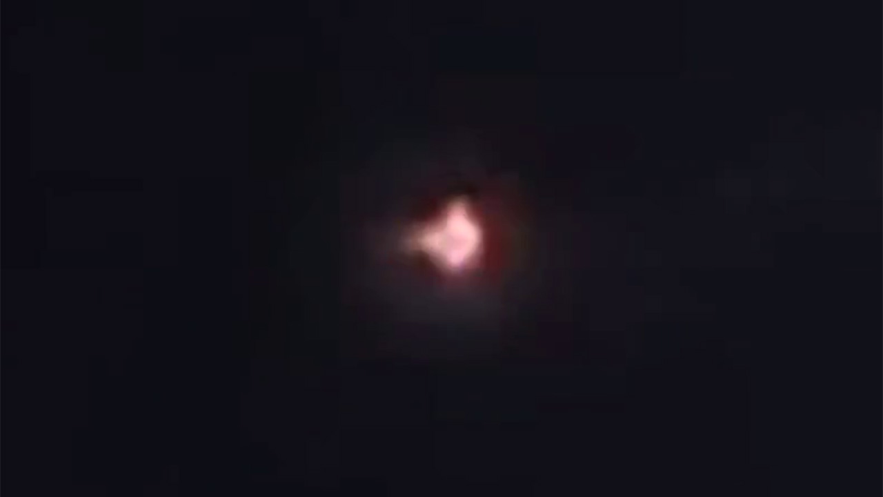 Screenshot published by FOX 9 from video described as released by the National Archives, showing the reported Anoka UFO as a bright multicolored light against a dark sky.
