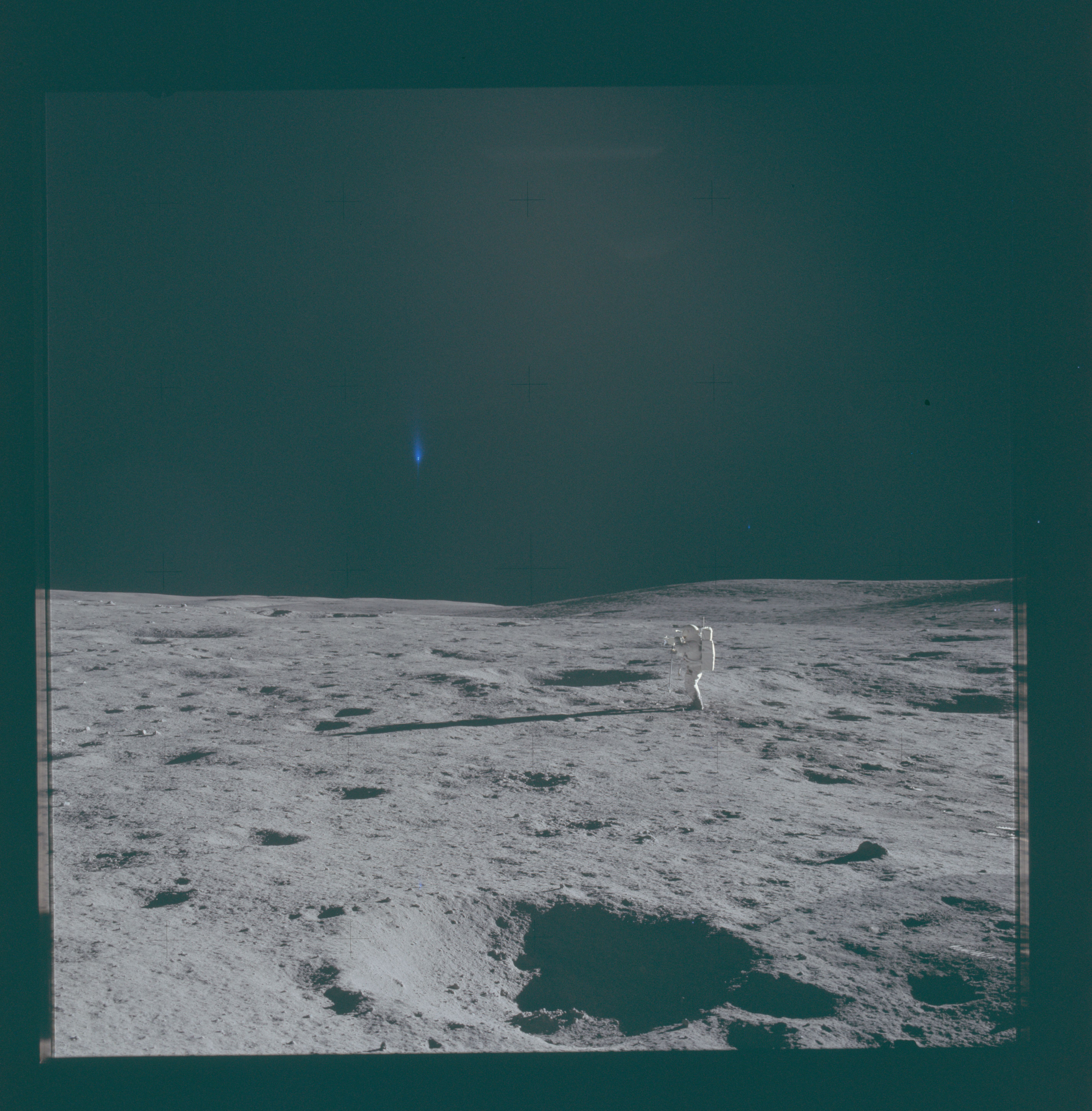NASA Apollo 14 photograph AS14-66-9301, showing Edgar Mitchell on the lunar surface and a blue vertical flare in the sky.