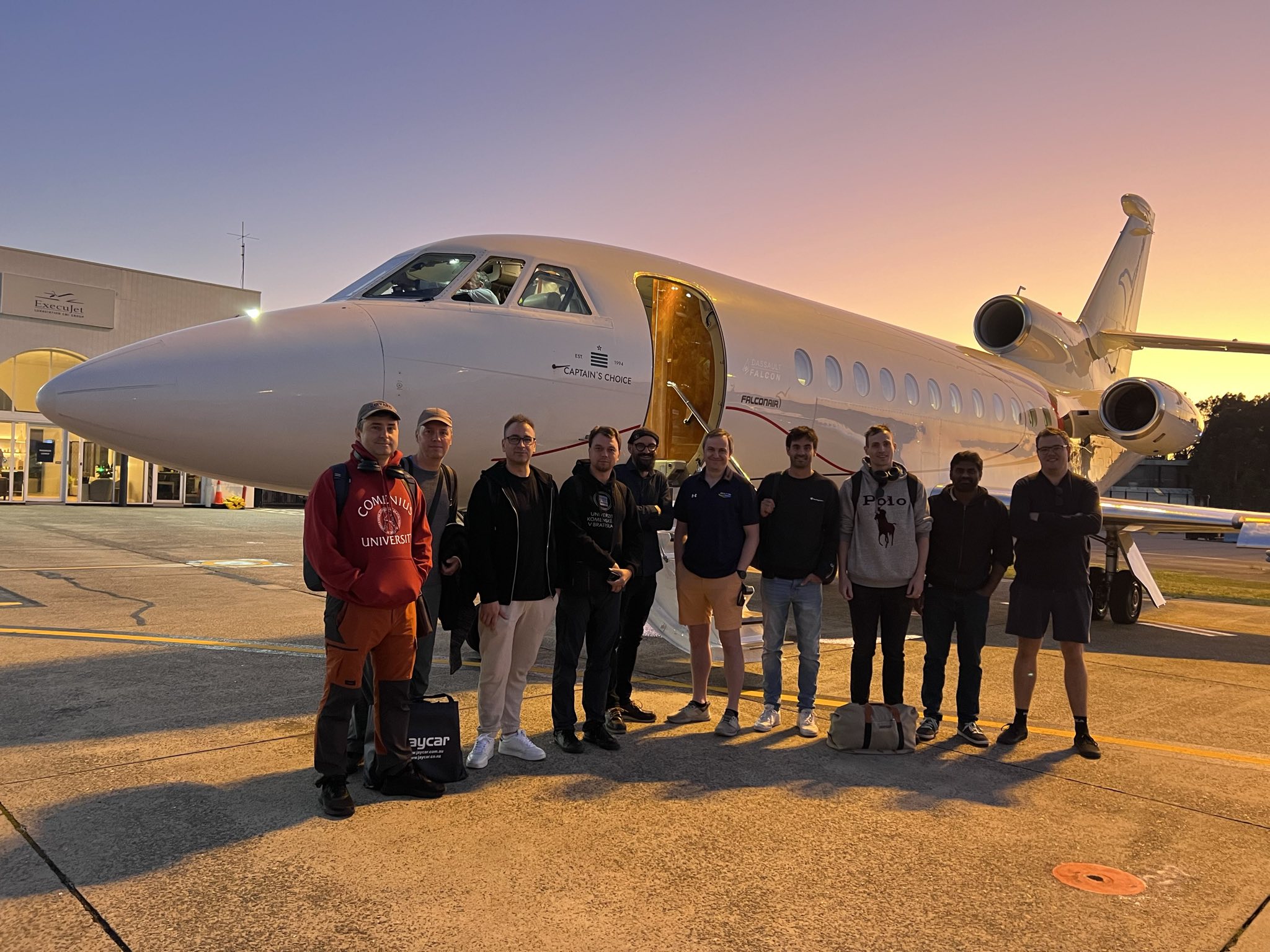 Members of ESA's 2024 Cluster reentry observation team standing in front of their aircraft at Sydney airport before takeoff.