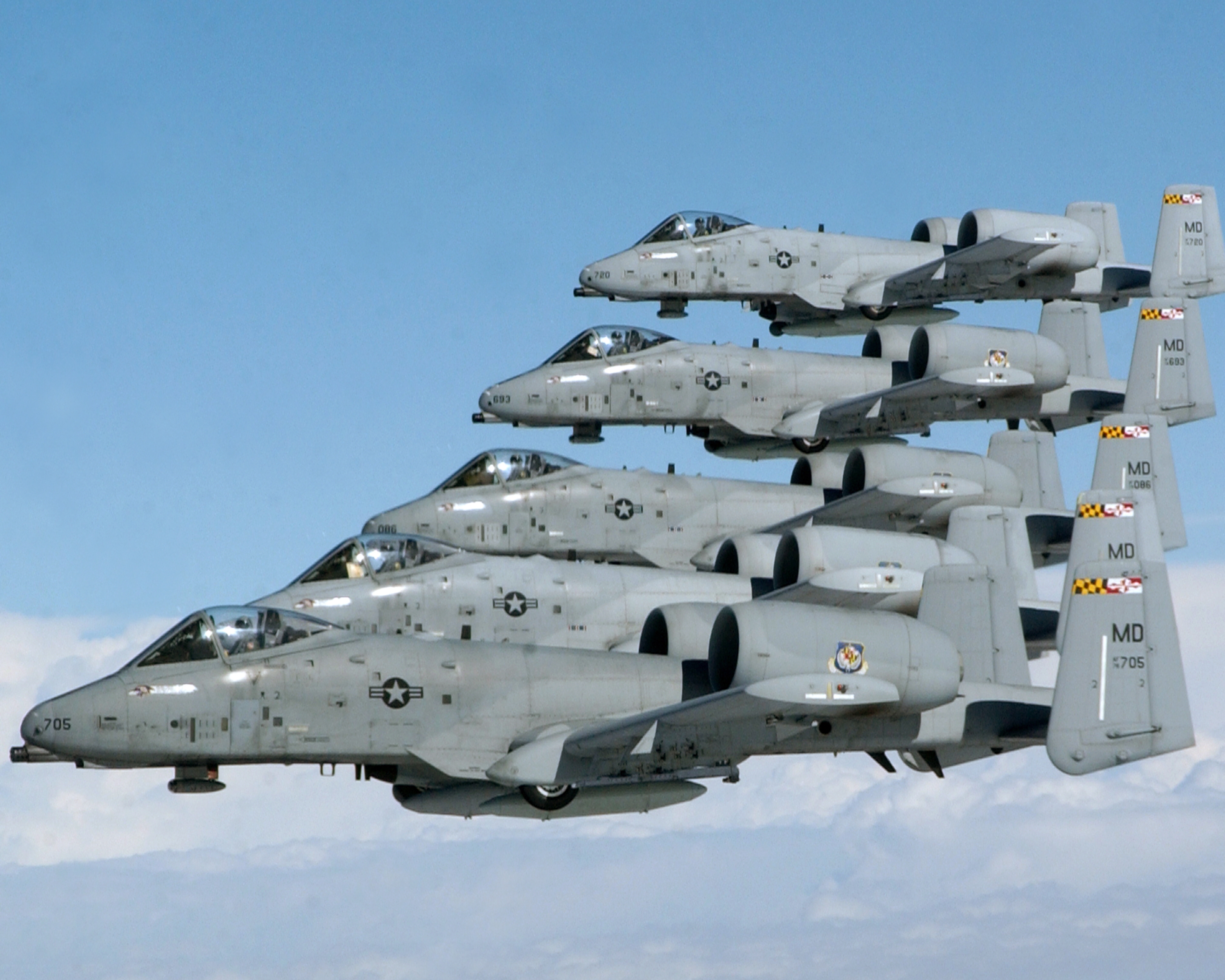Five A-10 Thunderbolt II aircraft in close echelon formation against a pale sky, photographed during a 175th Wing exercise. The Maryland Air National Guard tail code and Maryland flag are visible on the vertical stabilizers; this is the type of aircraft and unit that the U.S. Air Force identified as the source of both Phoenix Lights events on March 13, 1997.