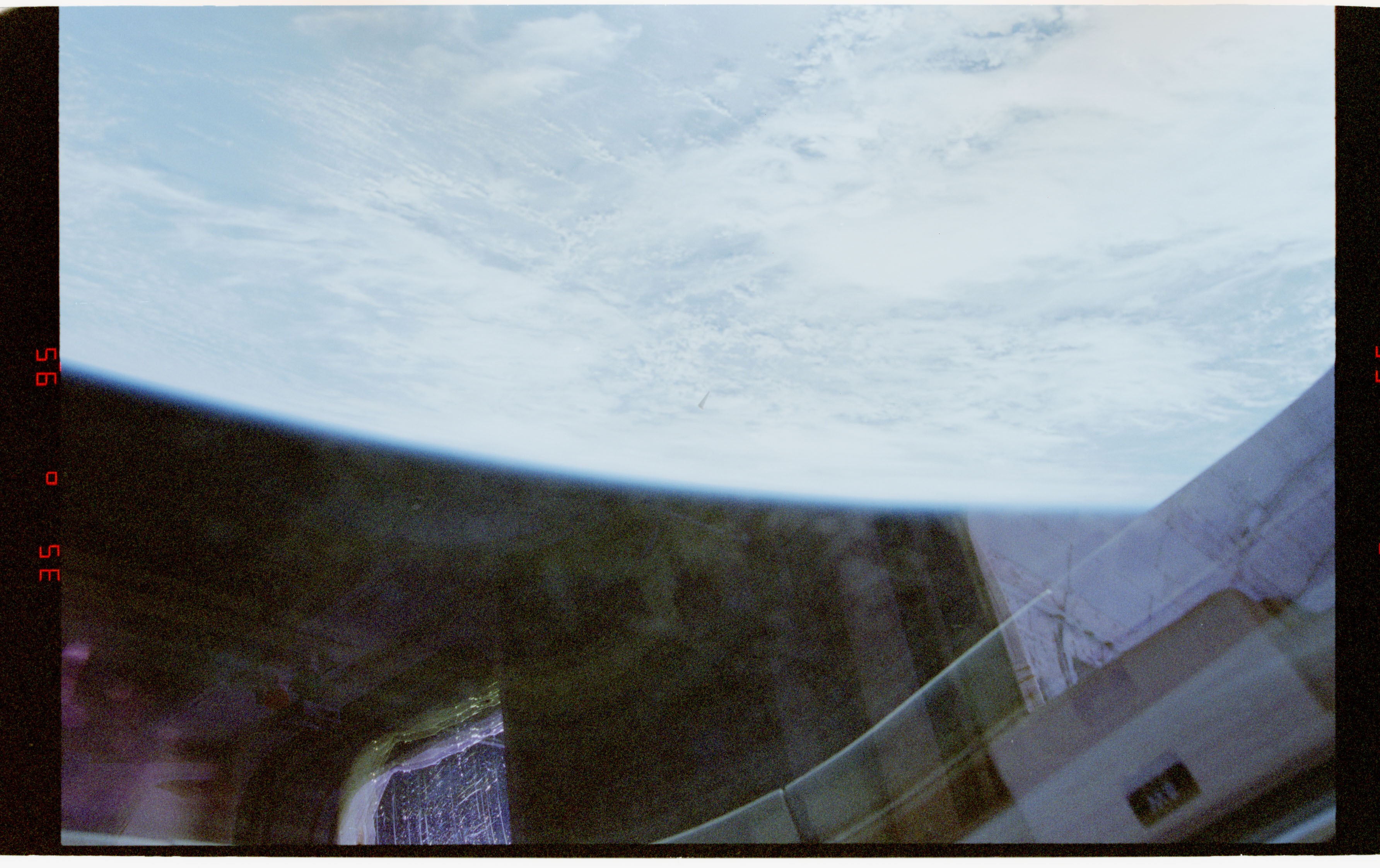 Release image D032: a faint small object appears above Earth near Columbia's payload bay.