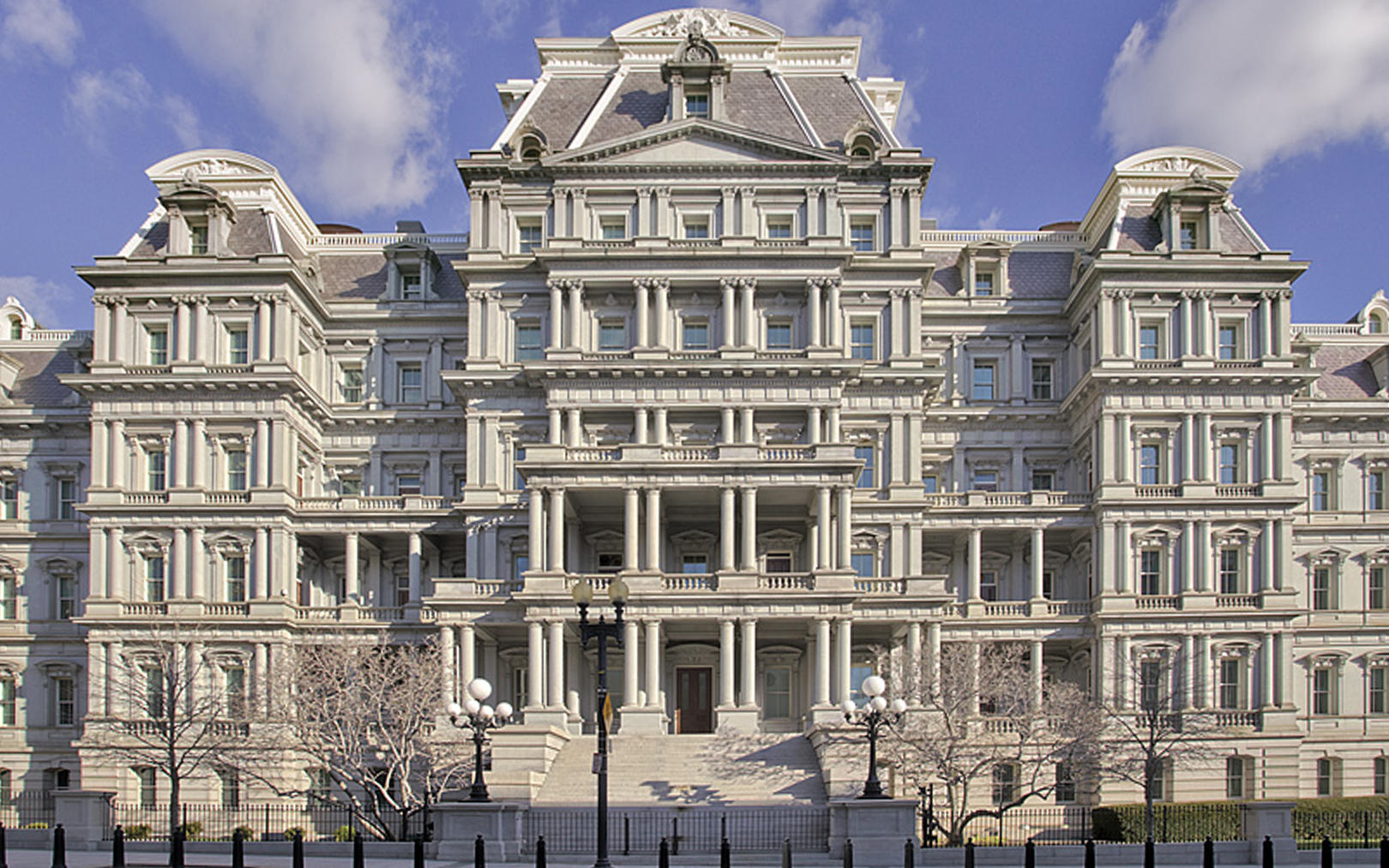 The Eisenhower Executive Office Building, the Second Empire-style stone building on the White House complex that houses the National Security Council staff, photographed in winter with snow on the ground and a U.S. flag above the central entrance.