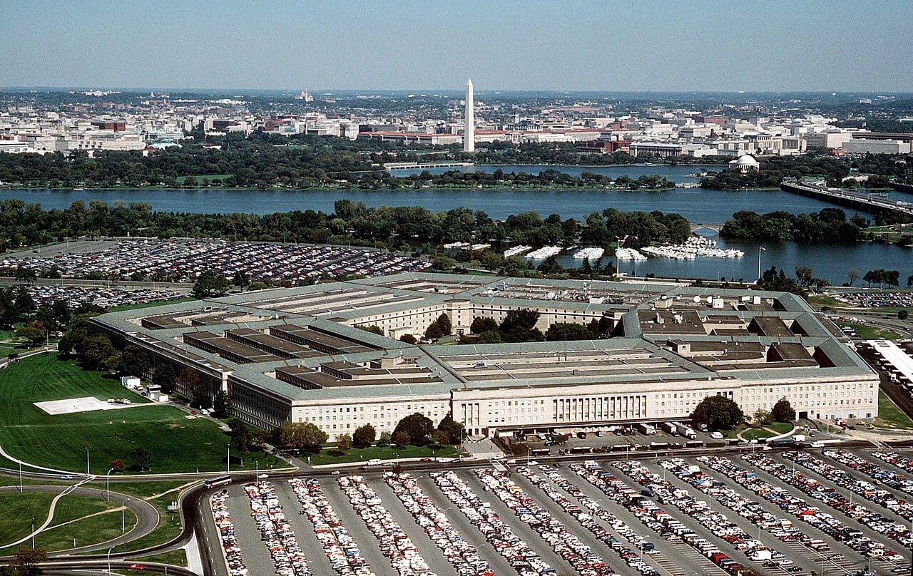 Aerial photograph of the Pentagon in Arlington, Virginia, looking north across the Potomac toward the Washington Monument and the National Mall. Public domain U.S. government photograph, Wikimedia Commons.