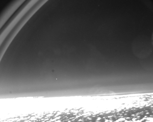 A bright point above Earth's curved horizon photographed from an aircraft during ESA's 2024 observation of the Cluster Salsa satellite reentry.