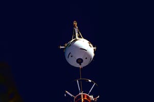 NASA photograph of the Tethered Satellite System during STS-75 deployment: a white spherical satellite hangs above the Space Shuttle Columbia payload bay against black space.