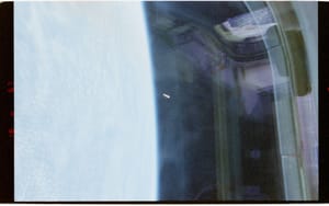 Official Release 04 image from STS-80: a small bright, elongated object appears against Earth and Columbia's payload-bay structure.